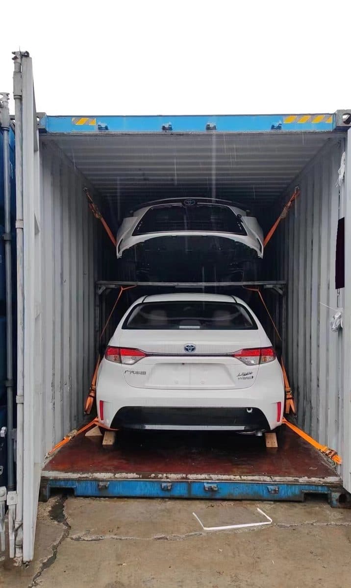 SUV secured with wheel straps inside a shipping container